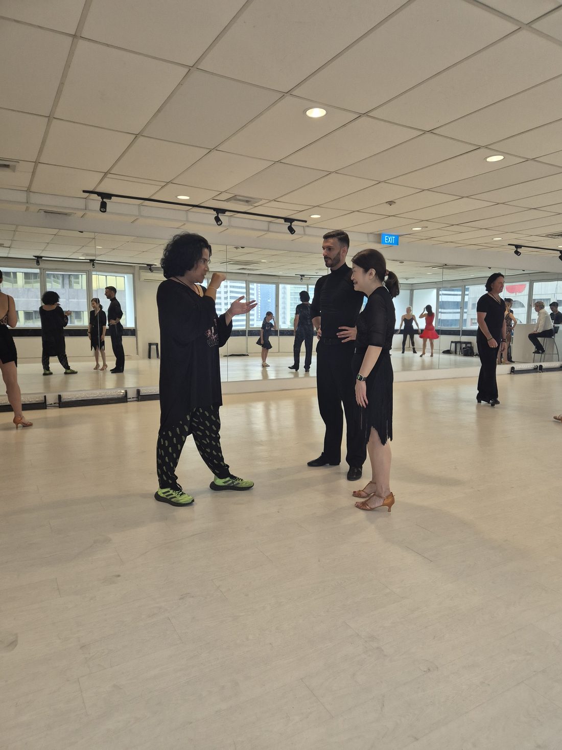 Adult students practising in a bright dance studio during a technique class