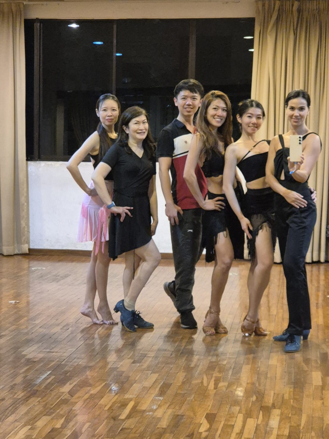 Raliza and a group of adult students posing in a dance studio after an evening class