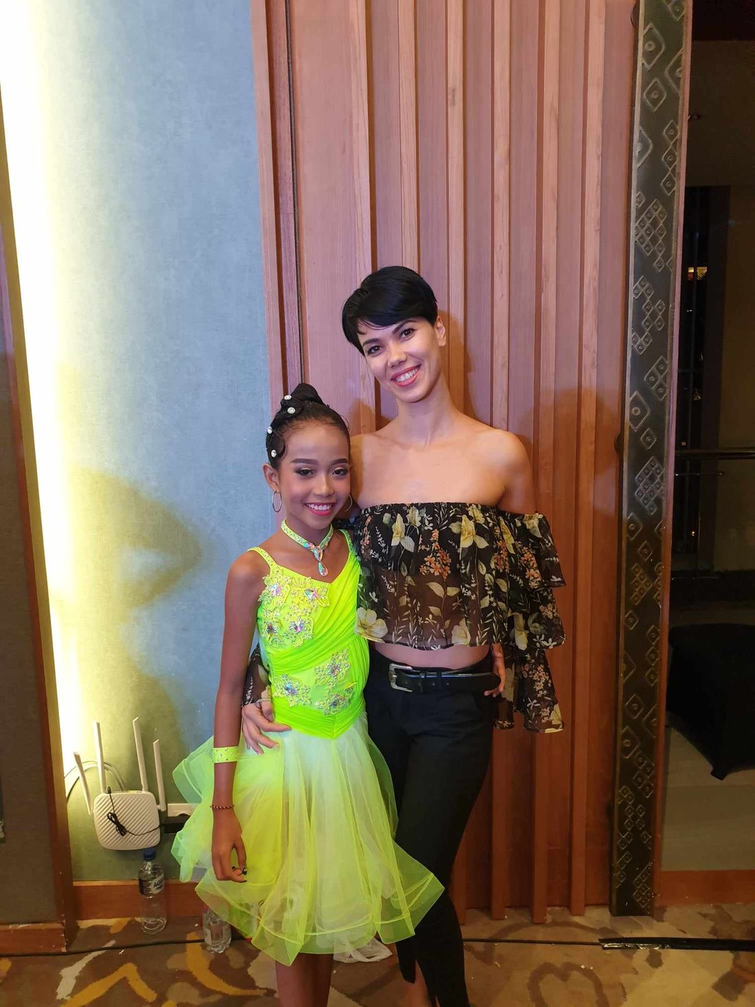 Raliza with a young student in a lime-green competition dress after a championship