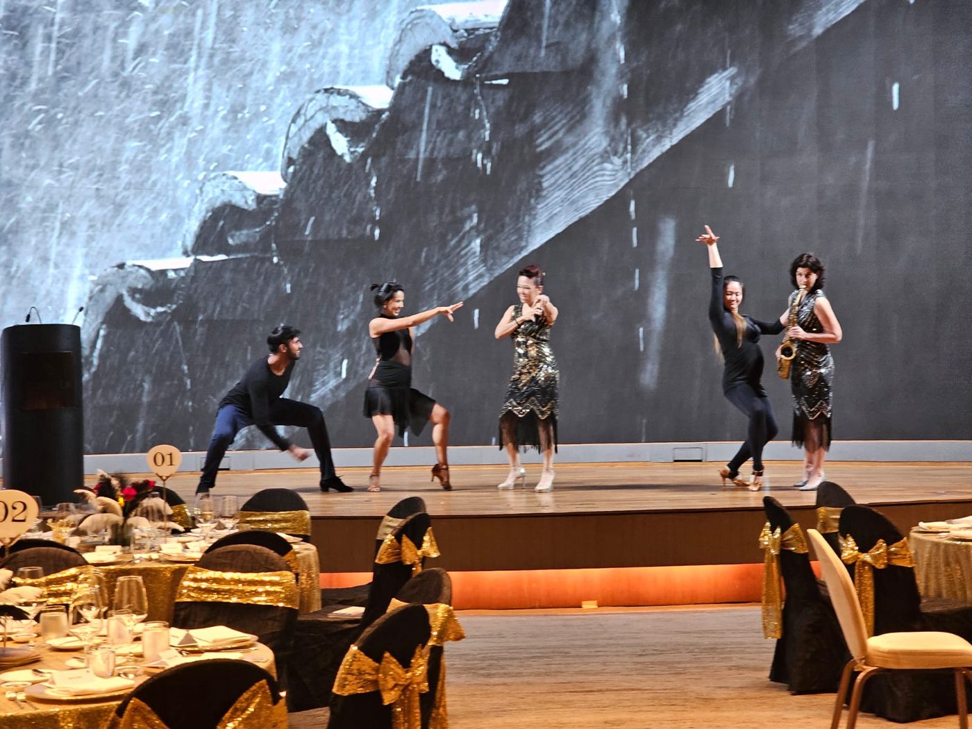 Students performing a choreographed Latin routine on stage at a school event